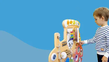 Un jeune garçon profite d'un jeu d'inspiration Montessori avec un train en bois.