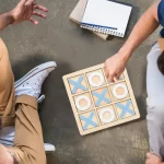 Un groupe de personnes jouant au Tic Tac Toe en bois.