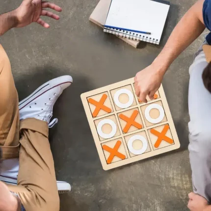 Deux hommes jouant au Tic Tac Toe en bois.