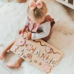 Une petite fille joue avec un Puzzle Personnalisé Prénom - en Bois.