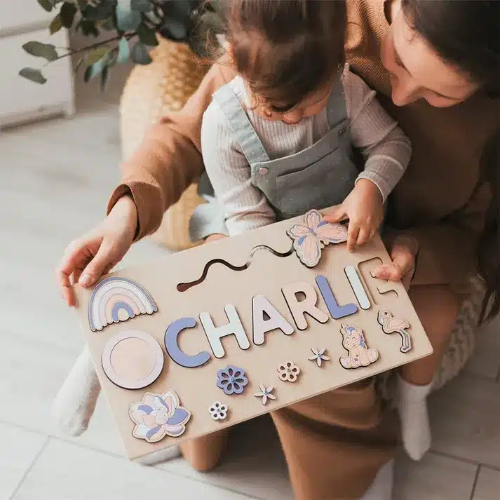 Une femme tenant un Puzzle Personnalisé Prénom en Bois - Cadeau Unique et Éducatif avec le prénom personnalisé "occhare".