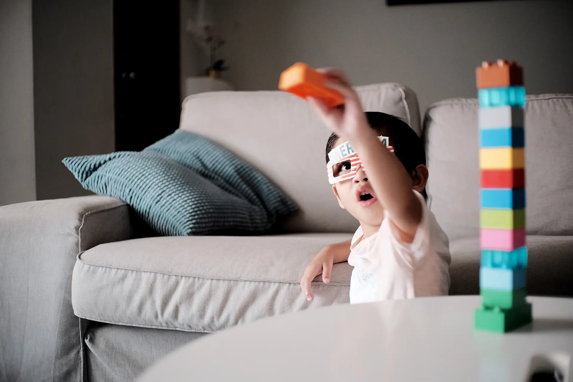 Un jeune garçon jouant avec des Legos dans un salon.