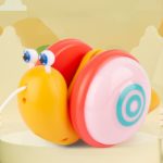 Le Jeu à tirer - Escargot Musical est assis sur le dessus d'une table.