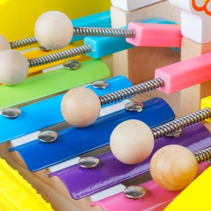 Un pousseur trotteur pliable avec des boutons en bois colorés.