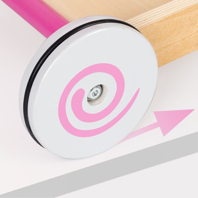 Un Trotteur Chariot de Marche Bébé rose - Petit Panier avec un rouet blanc sur une table en bois.