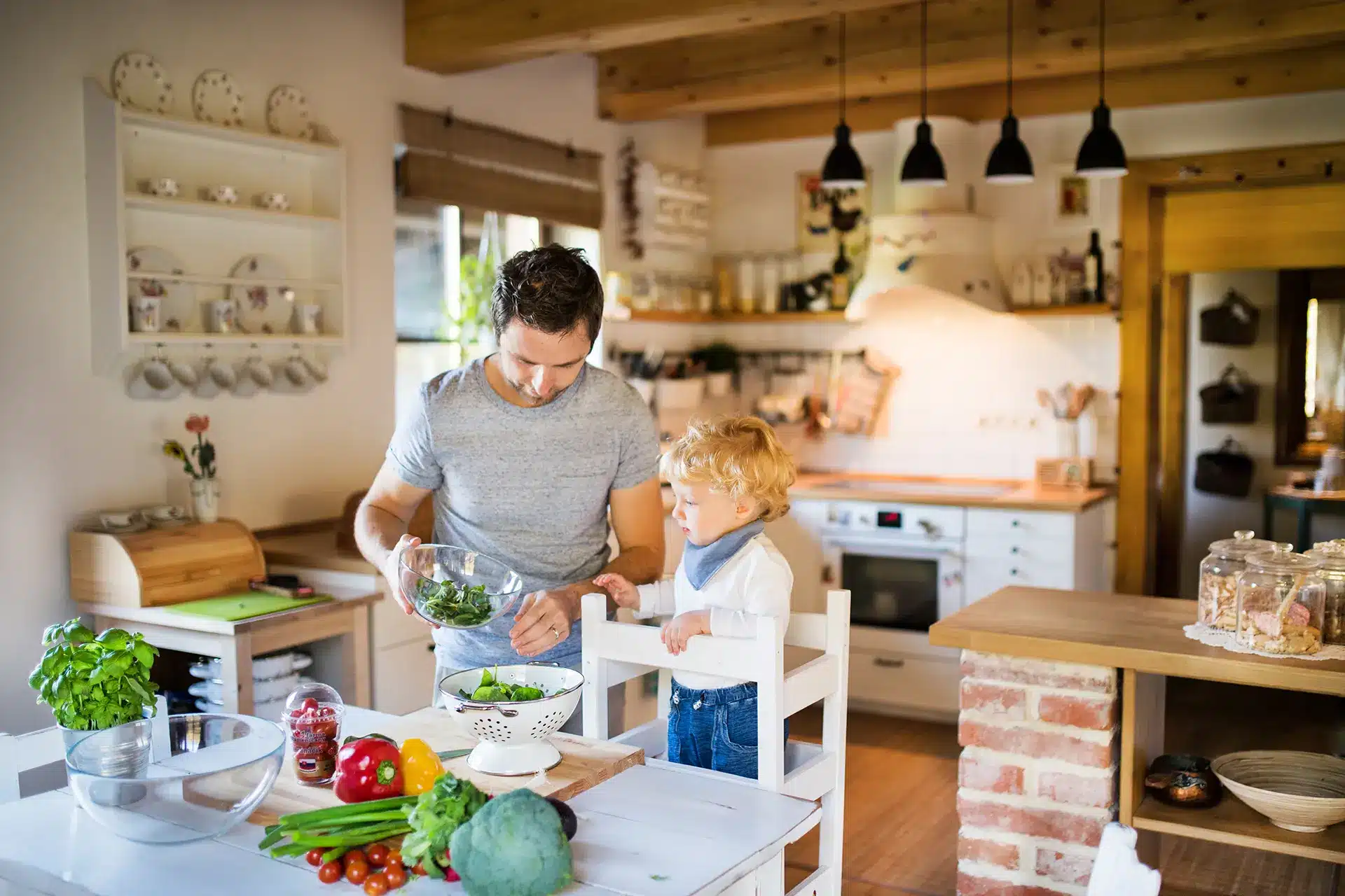 Un homme et un enfant vivant une expérience éducative dans une cuisine Montessori.