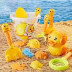 Jouets de sable avec canards et seaux sur le sable.