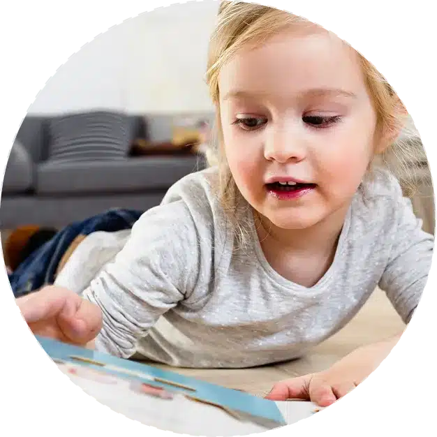 Une petite fille lisant un nouveau livre à la maison.