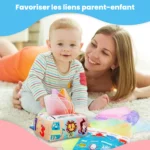 Une femme souriante et un bébé jouent par terre avec des mouchoirs en tissu colorés de la Boîte à Mouchoirs Magique et une boîte à jouets. Au-dessus d'eux, on peut lire : "Favoriser les liens parent-enfant.