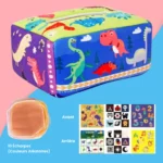 Boîte à Mouchoirs Magique rectangulaire et colorée avec des illustrations de dinosaures, un ensemble de foulards et des feuilles d'autocollants magiques aux motifs variés, le tout disposé sur un fond bleu et rose.