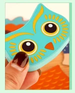 Une personne tenant un jouet puzzle hibou bleu.