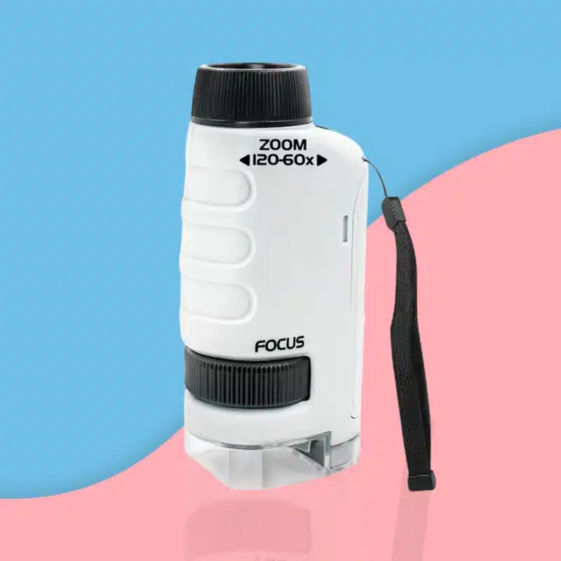 Le "Microscope de Poche pour Enfant - Portable - Grossis jusqu'à 120x" blanc à accents noirs, parfait pour les jeunes scientifiques curieux, est présenté debout sur un fond bleu et rose.