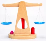 Une Balance Ancienne en Bois en bois avec une bouteille rouge et bleue dessus.