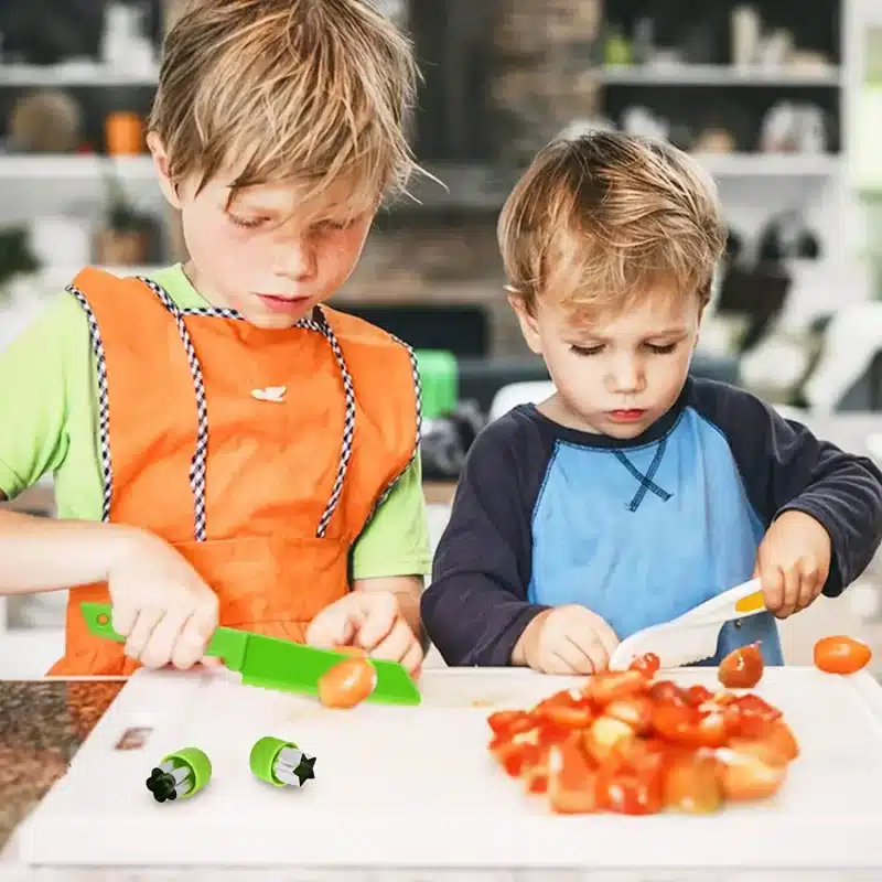 Deux jeunes garçons en tablier coupant des tomates sur un comptoir de cuisine, représentés dans un charmant style "dessin enfant".