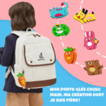 Un enfant portant un sac à dos blanc et un porte-clés en forme de carotte se tient à côté de dessins illustrés d'animaux et de légumes. Texte en français : "Mon porte-clés cousu main, ma création dont je suis fière !" Kit de Couture Enfants - Porte-clés à Faire Soi-Même en Sécurité.