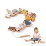 Un enfant arrange joyeusement les pièces du Jouet montessori animaux en bois, un ravissant puzzle éducatif aux formes variées et à la ficelle, tout en étant assis par terre.