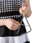 Une personne avec un Triangle de Musique – 10 cm doté d’une poignée jaune, prête à jouer.