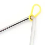 Gros plan du Triangle de musique de 10 cm doté d'une surface brillante et réfléchissante et d'une boucle en caoutchouc jaune attachée à son extrémité métallique arrondie.