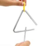 Mains tenant un Triangle de musique – 10 cm et un percuteur, avec l’instrument suspendu par un support jaune.
