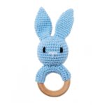 Les « Anneaux de dentition Animaux – bois et crochet » sont un adorable lapin bleu crocheté avec un anneau en bois, de longues oreilles et un visage simplement cousu.