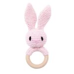 Conçus avec soin, les Anneaux de dentition Animaux – bois et crochet sont dotés d'un charmant manche en bois et d'un dessus crocheté en forme de lapin rose. Leurs longues oreilles offrent une prise parfaite pour les petites mains, ce qui en fait un accessoire indispensable pour apaiser les gencives de bébé.