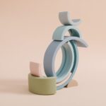 L'Arc en ciel Montessori en Silicone présente des demi-cercles et des arches empilés de couleur pastel, gracieusement équilibrés sur un fond beige.